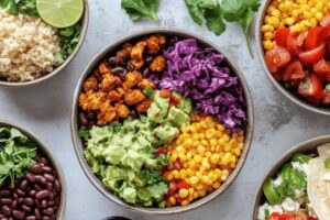 "Taco bowl ingredients including ground beef, rice, beans, cheese, salsa, and guacamole in a colorful bowl"

