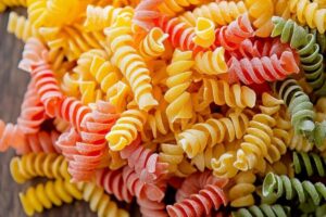 "A vibrant pasta salad with fusilli, vegetables, and fresh herbs, demonstrating the perfect texture and color balance."

