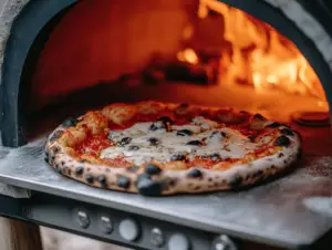 What temperature should I set my Ooni Koda 12 for pizza? 2 Ooni Koda 12 pizza oven with pizza being cooked at high temperature
