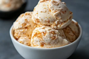 A close-up of not fried chicken ice cream showing its vanilla ice cream core and crunchy cornflake coating, mimicking fried chicken.

