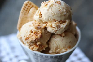 A close-up of not fried chicken ice cream showing its vanilla ice cream core and crunchy cornflake coating, mimicking fried chicken.

