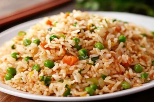 Restaurant-style Chinese fried rice in a wok, featuring fluffy rice, colorful vegetables, and savory seasonings like soy sauce and sesame oil. 