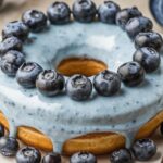 Blueberry Cheesecake Donut Cake with fresh blueberries and creamy cheesecake filling on top of a fluffy donut cake base.