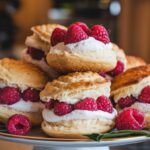 Freshly baked Raspberry Cream Cheese Puffs on a white platter.