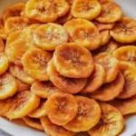 Sweet Cinnamon Air Fryer Banana Chips 7 iymarecipes Sweet Cinnamon Air Fryer Banana Chips in a bowl, crispy and golden with a dusting of cinnamon sugar, served as a healthy snack.