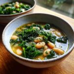 Close-up of a bowl of One-Pot White Bean & Kale Soup with beans and kale.