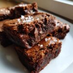 Close-up of Crispy-Edge Fudgy Brownie Bars with Salted Toffee on a white plate.