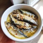 Close-up of a white bowl filled with fresh sardines, prepared for a Fresh Sardine Cat Dinner.