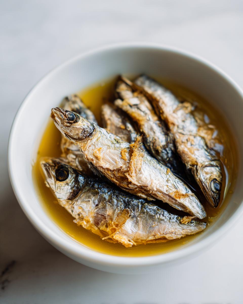 Close-up of fresh sardines in a white bowl, ready for a Fresh Sardine Cat Dinner.