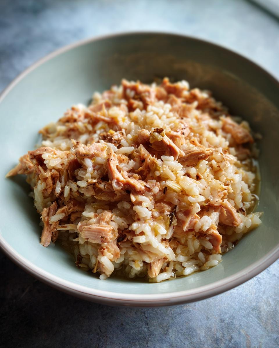 Close-up of a high-calorie cat recovery meal in a light blue bowl, showing rice and meat.