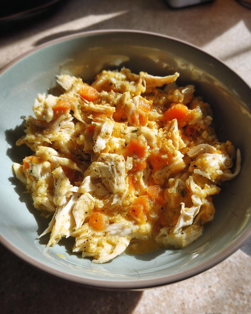 Close-up of a high-protein senior cat meal in a bowl, with shredded chicken and carrots.