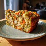 A slice of delicious Homemade Cat Birthday Cake with vegetables and chicken, served on a plate.