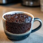 Close-up of a Microwave Fudgy Brownie for One in a mug, freshly made and ready to eat.