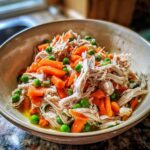 Close-up of a Spring Chicken Cat Meal Bowl with shredded chicken, carrots, and peas.