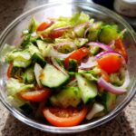 Close-up of a fresh salad with tomatoes, cucumbers, red onion, and lettuce; perfect for a 15-Minute Salad.