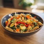 Close-up of a bowl of delicious Asian pasta salad with vegetables and sesame seeds. The pasta salad asian is ready to eat.