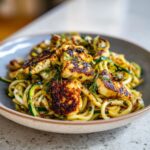 Close-up of a bowl of grilled halloumi and zucchini pasta salad, a delicious and healthy dish.
