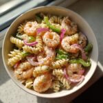 Overhead shot of a bowl of delicious pasta salad shrimp with vegetables and creamy dressing.