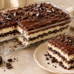 Creamy Oreo Carlota layered with chocolate sandwich cookies, smooth cream filling, and glossy chocolate fudge topping.
